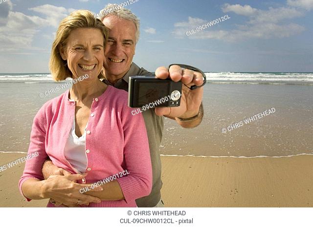 Couple taking photograph on a beach