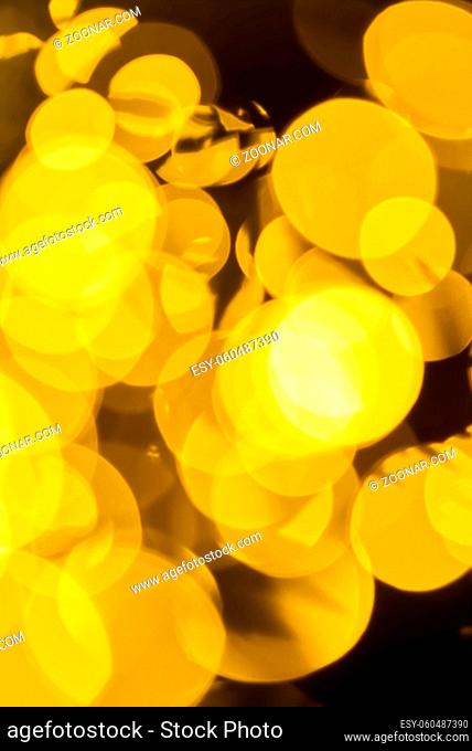 blurred christmas lights abstract background on dark backdrop. Yellow Circular reflections of Christmas lights