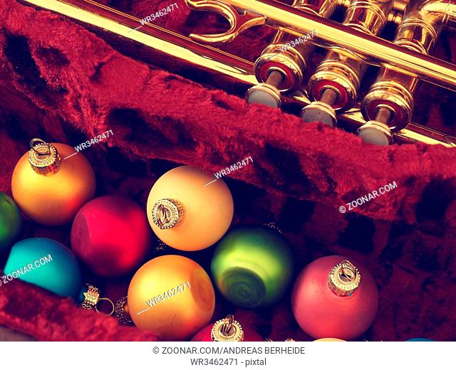 Colorful vintage Christmas baulbes with an old used trumpet, Christmas music background