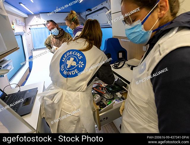 11 May 2020, Bavaria, Munich: A female doctor (2nd from left) and two assistants treat a patient in a treatment bus of the organisation ""Ärzte der Welt""