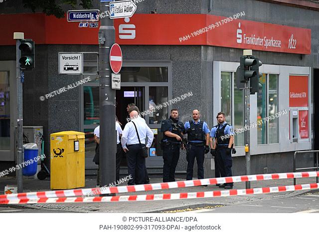 02 August 2019, Hessen, Frankfurt/Main: Police officers are standing in front of a branch of the Frankfurter Sparkasse on Düsseldorfer Straße