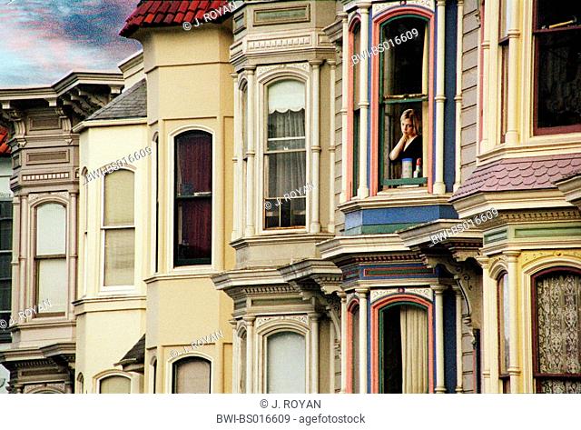 woman standing in window and looking out, USA, San Francisco