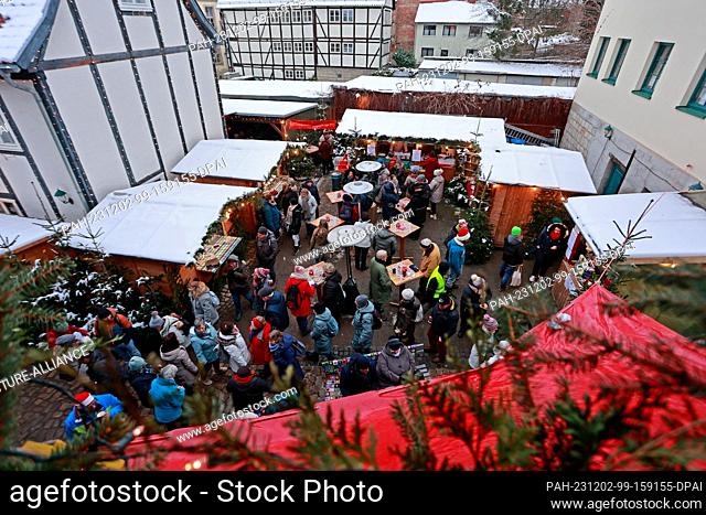 02 December 2023, Saxony-Anhalt, Quedlinburg: Visitors to Advent in den Höfen at a small Christmas market in a backyard. Advent in den Höfen has been around for...