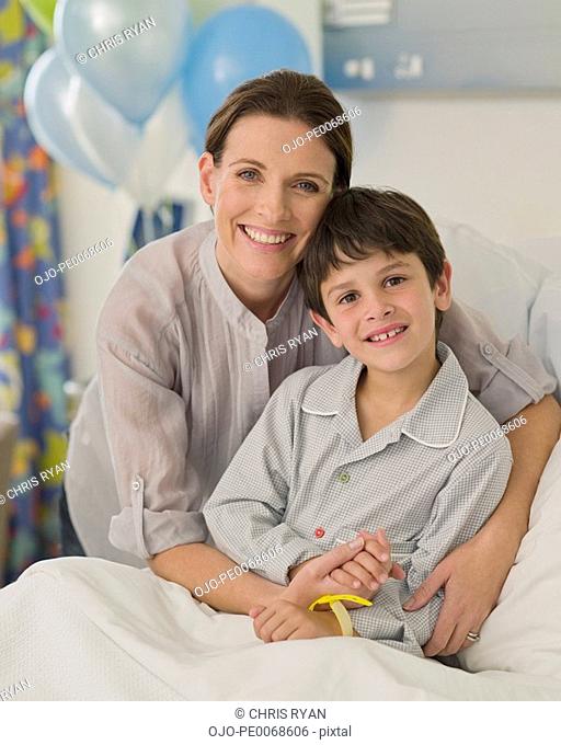 Mother hugging son in hospital room