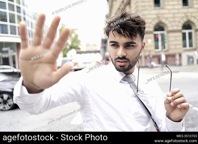 Businessman on the street making stop gesture
