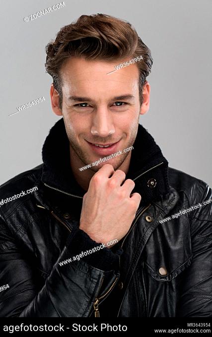Fashion man, Handsome serious beauty male model portrait wear leather jacket, young guy over gray background