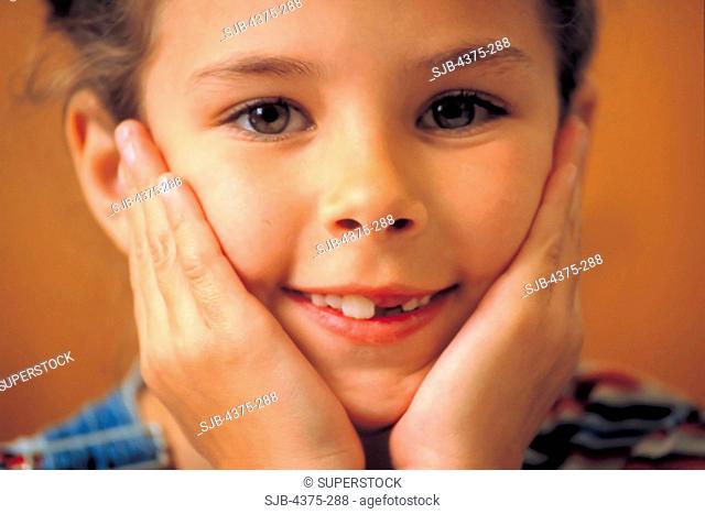 Portrait of Smiling Young Girl with Missing Tooth