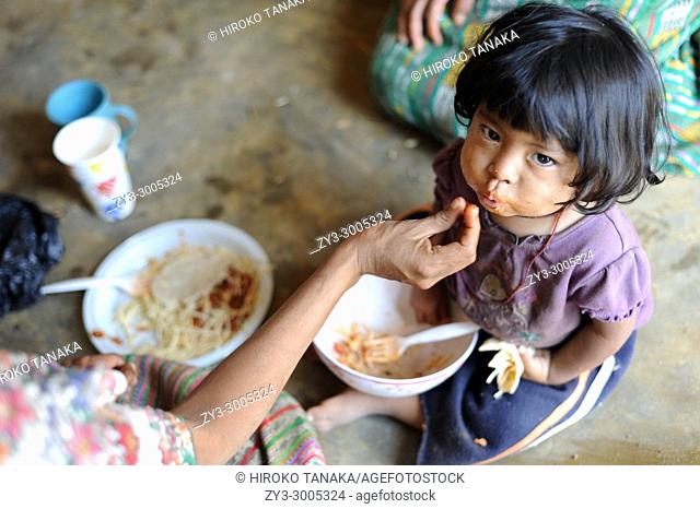 A maya indigenous girl is fed lunch provided by local NPO in Aqua Escondida, Solola, Guatemala