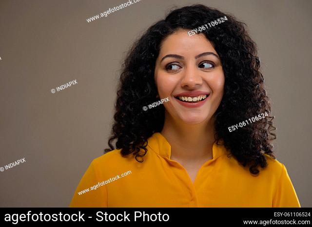 Young woman in yellow outfit looking with cross-eyed