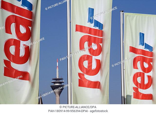 14 September 2018, North Rhine-Westphalia, Duesseldorf: Flags with the Real logo waving in front of a Real supermarket. The Metro retail group plans to sell the...