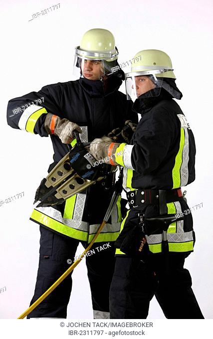 Firefighters holding a hydraulic spreader tool where the metal parts are spread apart to rescue people, professional firefighters from the Berufsfeuerwehr Essen