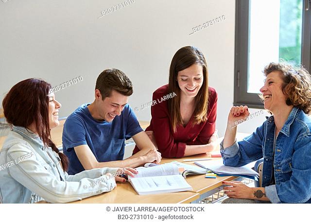 Students laughing at desk in classroom