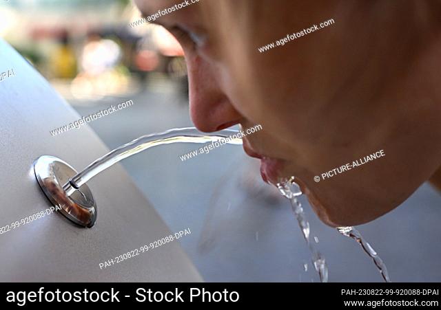 PRODUCTION - 22 August 2023, Rhineland-Palatinate, Mainz: Maren Brenning drinks from a drinking fountain on Rebstockplatz in downtown Mainz