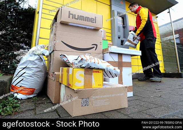 22 December 2020, Mecklenburg-Western Pomerania, Rostock: In front of a DHL Packstation, Matthias Peters has stacked up parcel shipments that he has either...