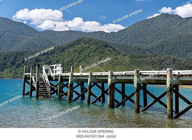 New Zealand, South Island, Marlborough Sounds, Tennyson Inlet, wooden jetty and hills in the sounds of Penzance Bay