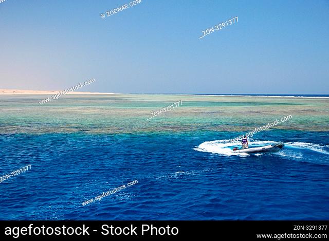 schnelles schlauchboot beim umdrehen bei korallenriff im meer