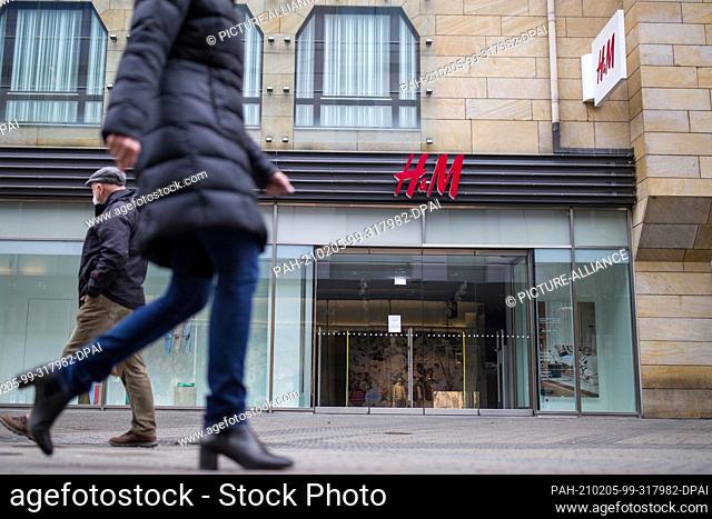 05 February 2021, Bavaria, Nuremberg: Passers-by walk past a branch of the H&M fashion chain in the pedestrian zone in the city centre