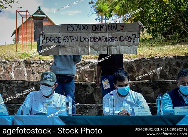Demonstrators hold a sign against the dissapeared people during protests that reads ""Criminal State, Where Are The DIssapeared"" during the public hearing...