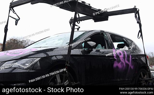 30 January 2020, Berlin: A destroyed car is lifted onto a tow truck, on a car door and on the bonnet there is the abbreviation ""L34"" in pink writing