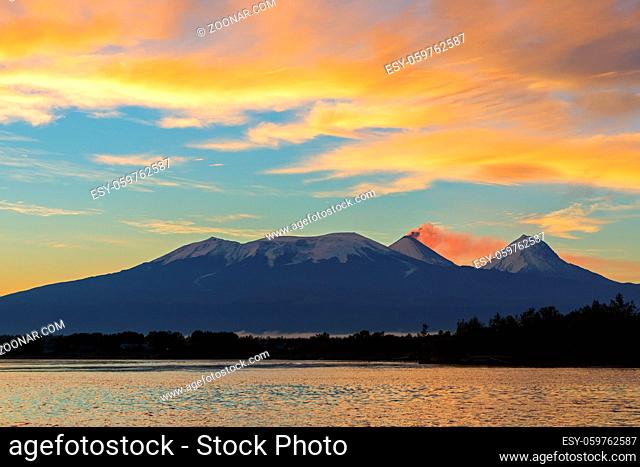 Beautiful sunrise over the volcanoes Kluchevskaya group with reflection in the river Kamchatka