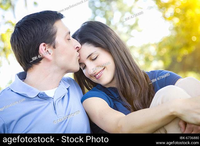 Young attractive couple intimate portrait outdoors in the park