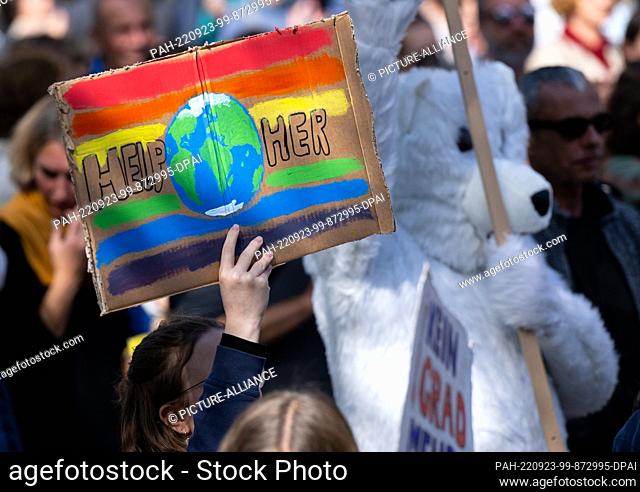 23 September 2022, Bavaria, Munich: A woman takes part in a demonstration for the global climate strike and holds a placard with the inscription ""Help Her"" in...
