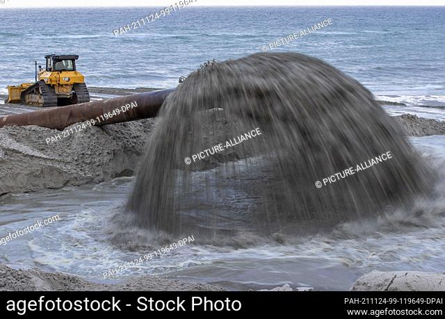 17 November 2021, Mecklenburg-Western Pomerania, Ahrenshoop: New sand is flushed via a pipeline from a special ship onto an approximately four-kilometre stretch...