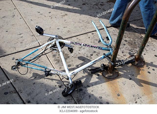 Denver, Colorado - A bicycle frame locked to a bike stand with the wheels removed