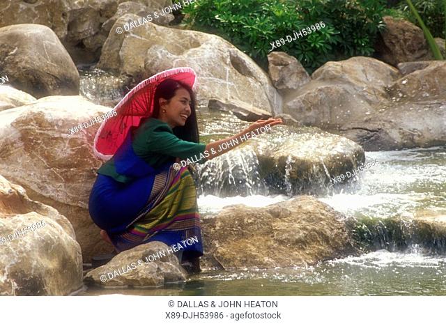 Asia, Thailand, Ayutthaya, Thai Woman Playing at Waterfall