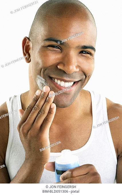 African man applying face cream