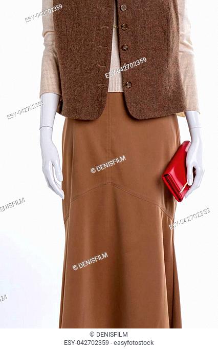 Female waistcoat, skirt and wallet. Long brown skirt and red leather purse close up, cropped image