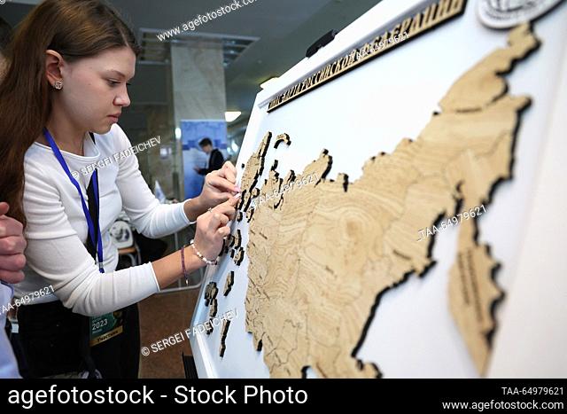 RUSSIA, MOSCOW - NOVEMBER 19, 2023: A woman puts together a jigsaw puzzle showing a map of Russia before an annual Russian geography test