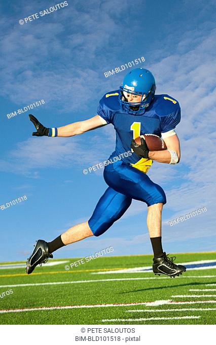 Caucasian football player running with football