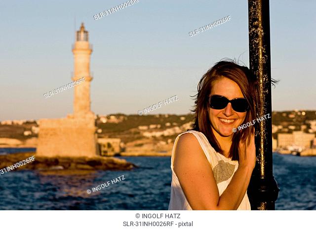 woman smiling at the camera in front of harbour