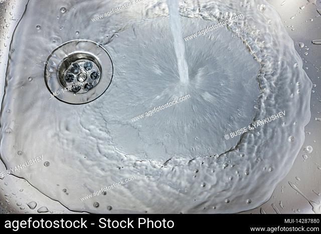 Water flows from a faucet into a sink