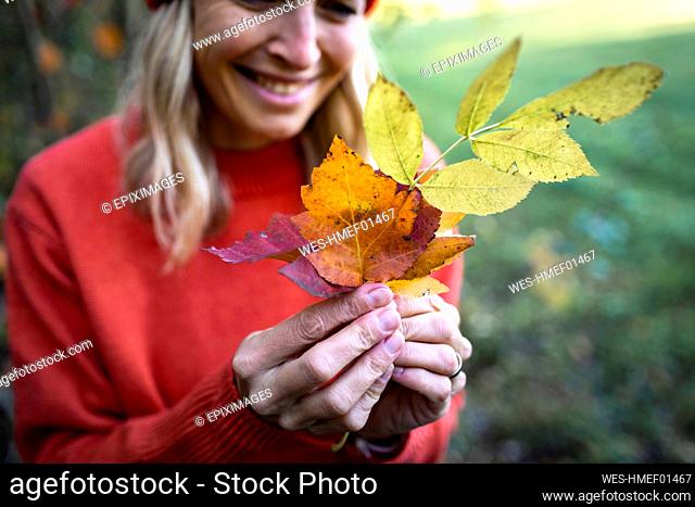 Mature woman holding autumn leaves