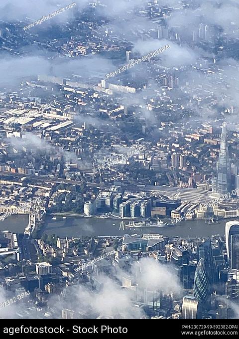 29 July 2023, Great Britain, London: Tower Bridge (v) and The Shard skyscraper (r) on the Thames, seen from the airplane