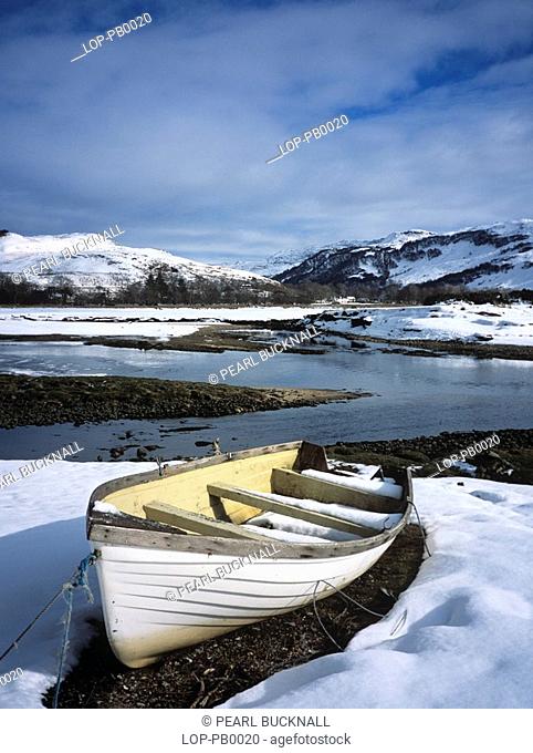 Scotland, Highland, Glenelg, Boat by the Glenmore river estuary in Galltair, with snow on the ground in late winter