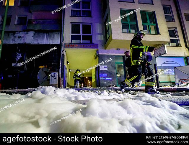PRODUCTION - 12 December 2023, Hesse, Offenbach: A thick blanket of foam covers the scene during an extinguishing operation at a fire in a three-storey...