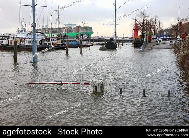 20 December 2023, Hamburg: The water of the Elbe floods a parking lot in Hamburg-Övelgönne. The Federal Maritime and Hydrographic Agency (BSH) is expecting...