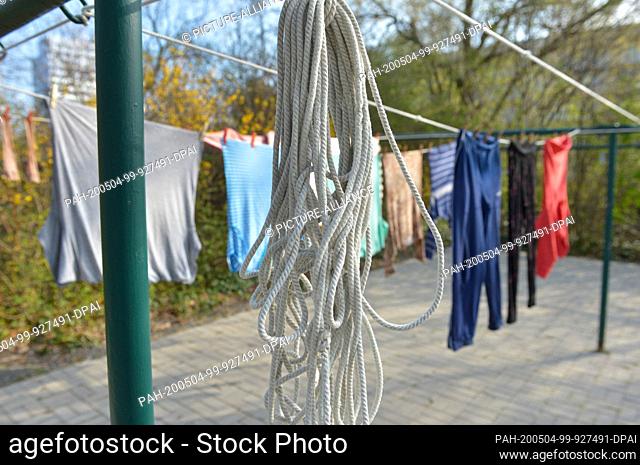 09 April 2020, Saxony, Leipzig: Freshly laundered laundry is hanging on a clothesline in a laundry drying area directly next to a residential building in...