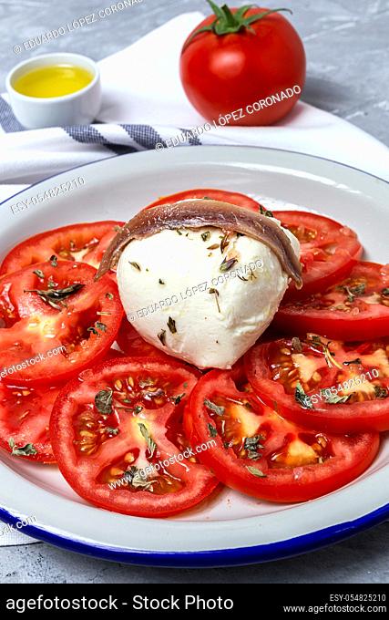 Ensalada de tomate casera saludable con mozzarella, anchoas y orégano. Concepto de comida sana