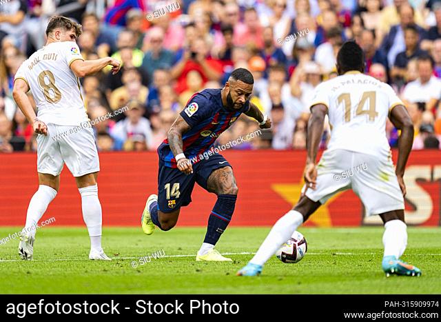 Memphis Depay (FC Barcelona) duels for the ball against Raul Guti (Elche CF) and Palacios (Elche CF) during La Liga football match between FC Barcelona and...