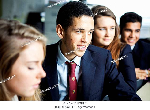 Teenage schoolchildren sitting at desks