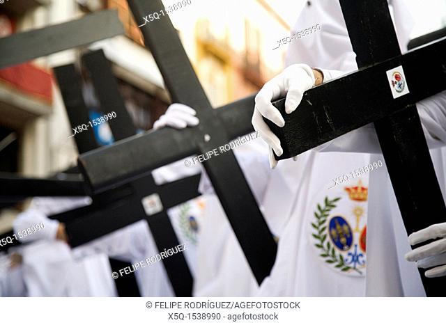 Hooded penitents bearing wooden crosses, Palm Sunday, Seville, Spain