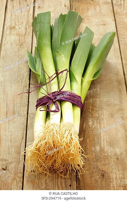 A bunch of leek on a wooden surface
