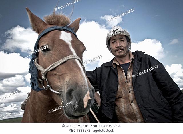Portrait of a Nomad with his horse in Northern Mongolia