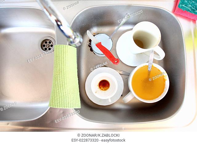 Dishwashing. White dishes in the kitchen sink