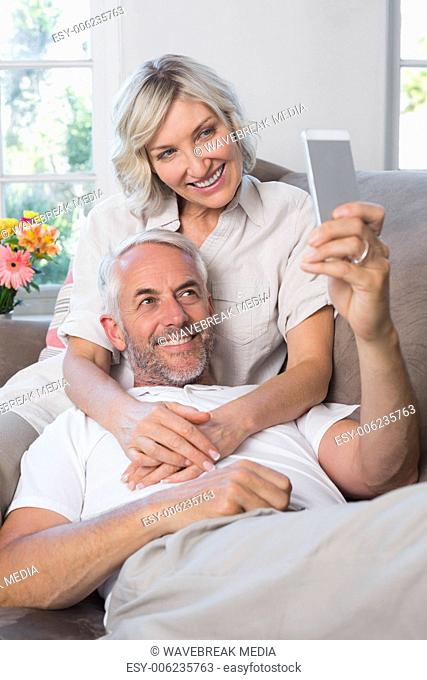 Mature couple photographing themselves with cellphone