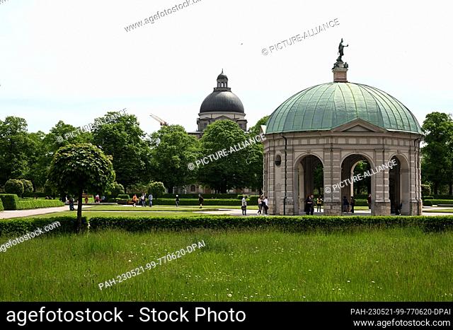 21 May 2023, Bavaria, Munich: Tall grass grows in the courtyard garden in front of the Diana Temple, the State Chancellery can be seen in the background